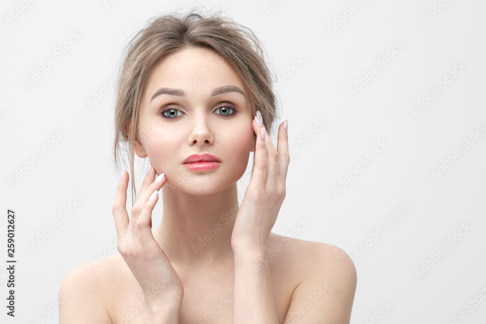 Beauty portrait of a young beautiful blonde woman, with bare shoulders, touches the hands with even clean skin. Beautiful plump red lips. Beauty portrait of a young beautiful blonde woman, with bare shoulders, touches the hands with even clean skin. Beautiful plump red lips.