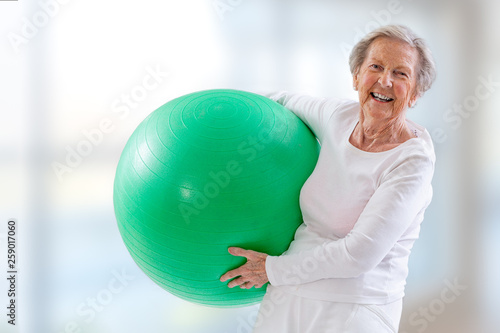 Senior Woman with fitness ball in gym.