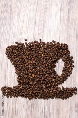 Roasted coffee beans like a cup on a wooden background © Albert Bugaev