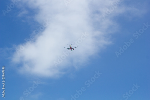 Passenger plane flying in the blue sunny sky