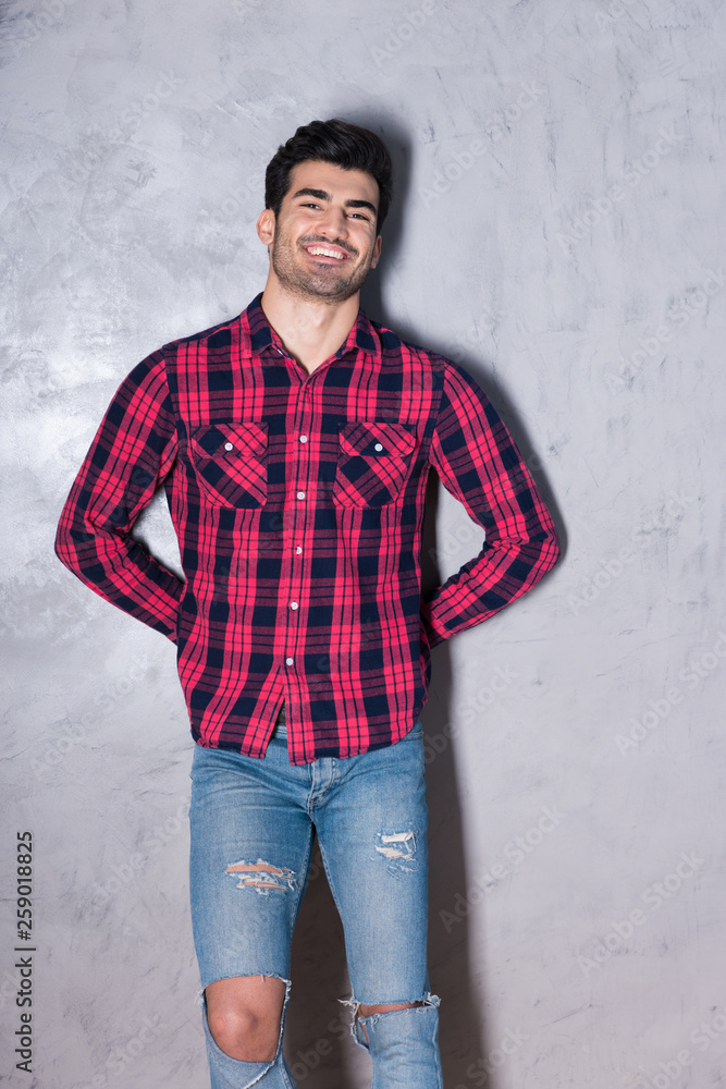 A happy young man in a red checkered shirt A happy young man in a red checkered shirt