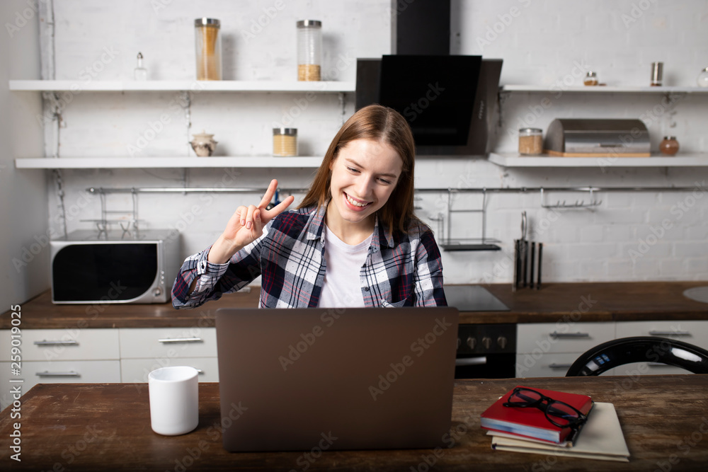 Happy woman working at home in the morning. Girl drinking coffee. She is using her laptop Happy woman working at home in the morning. Girl drinking coffee. She is using her laptop