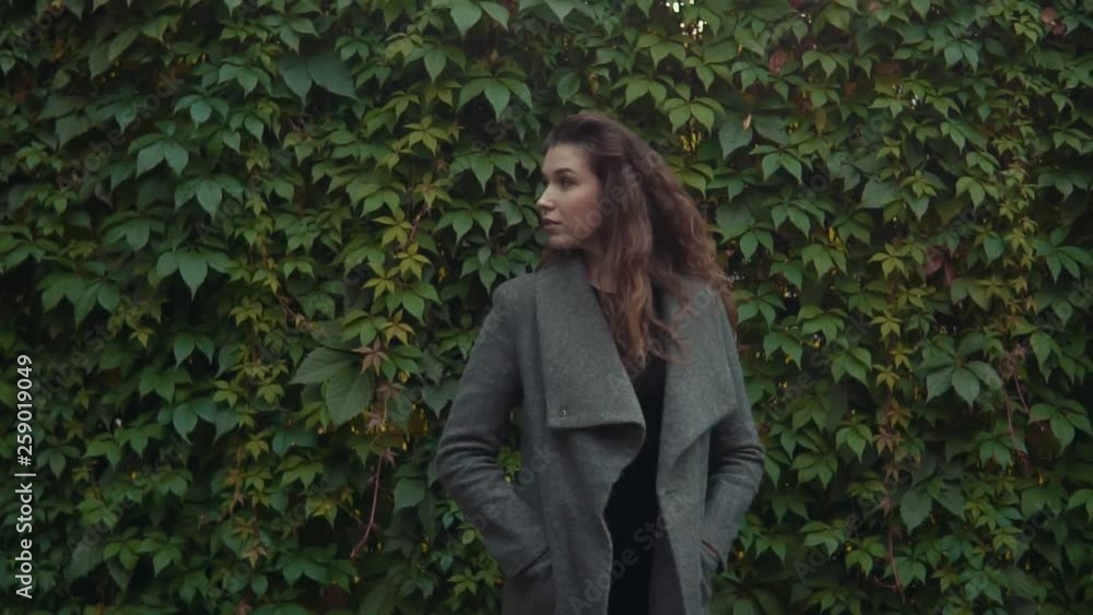 Young beautiful brunette woman in coat smiling in slow motion with copy space. Close up shot Young beautiful brunette woman in coat smiling in slow motion with copy space. Close up shot