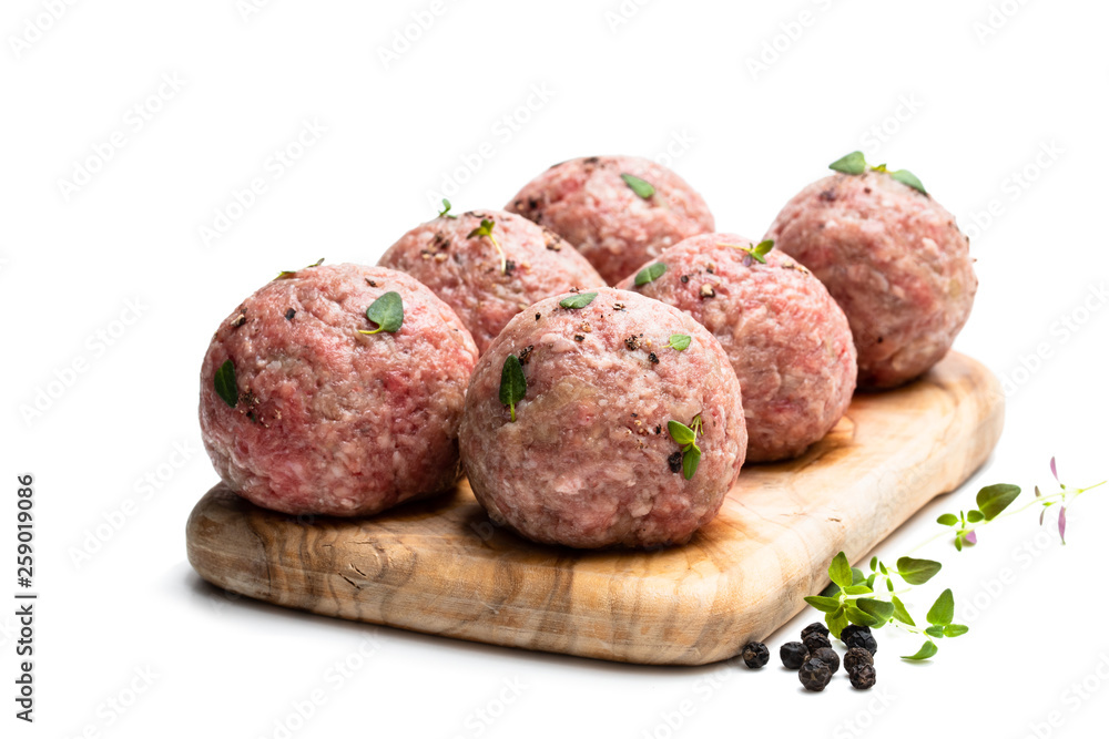 Raw meat balls on wooden cutting board isolated on white Raw meat balls on wooden cutting board isolated on white