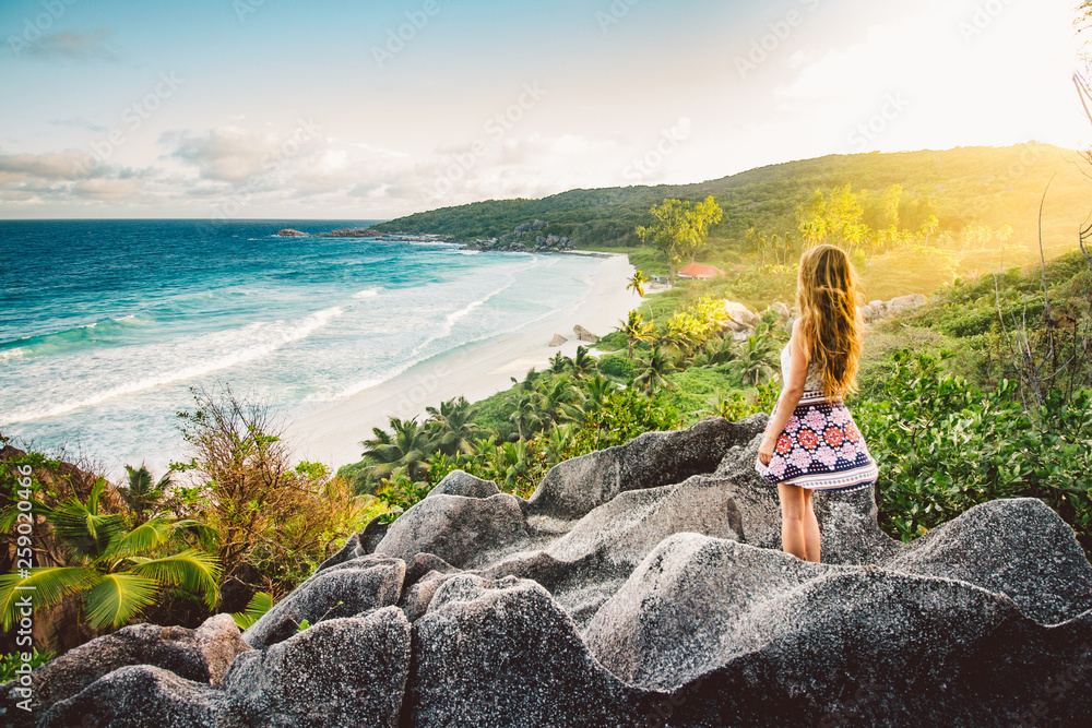 A young girl admiring the view at Grande Anse beach located on La Digue Island, Seychelles