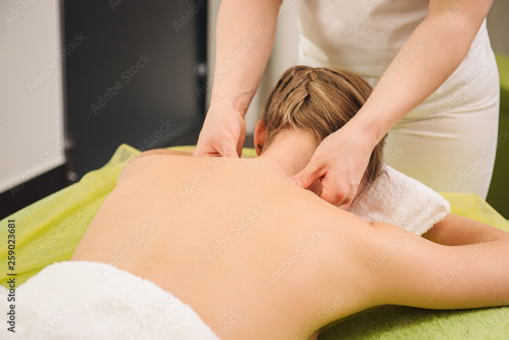 Woman having neck and shoulder massage in spa center Woman having neck and shoulder massage in spa center