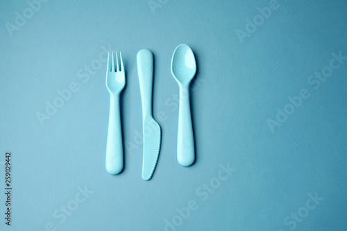 Blue plastic dishes on blue background. Concept