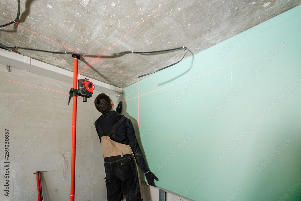 drywall installation, wall alignment. Laser measurement during