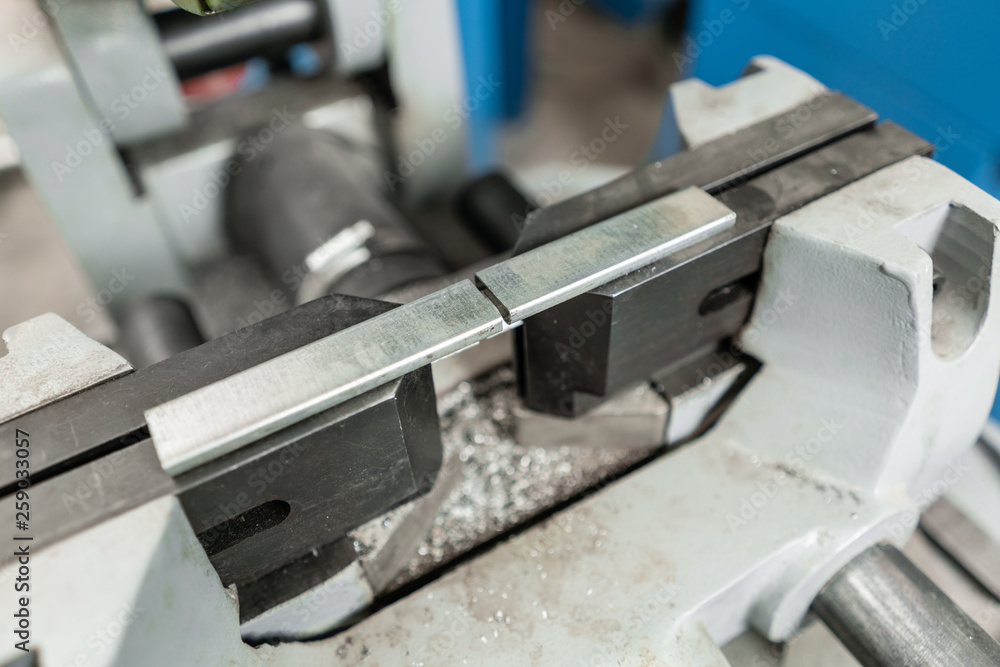 vise to secure the workpiece. Circular saw machine. Cutting a metal and steel with with sharp, circular blade in workshop interior. Tool store or exposition stand. vise to secure the workpiece. Circular saw machine. Cutting a metal and steel with with sharp, circular blade in workshop interior. Tool store or exposition stand.