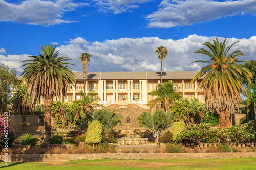 Park and garden with yellow palace building hidden behind tall palms, Windhoek, Namibia © vadim.nefedov