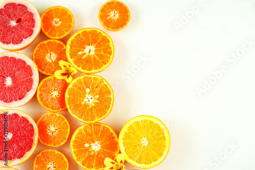 Colorful citrus fruit including blood grapefruit, mandarins, oranges, lemons on white background with copy space.