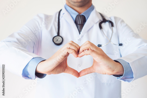 Close up of doctor's hands making heart shape isolated on white background