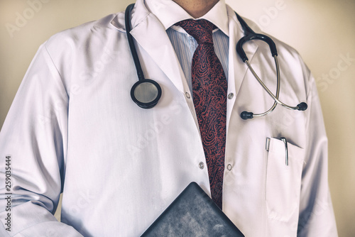 Bright close up of male doctor with stethoscope and holding patient file, Medical concept