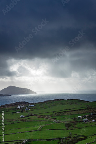 a view of the wild atlantic way off the coast of the ring of kerry in ireland showing skellig michael and surrounding islands in beautiful strong light with cloudy skies 