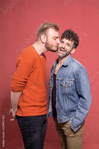 two men gay couple, one kissing other one in cheek.