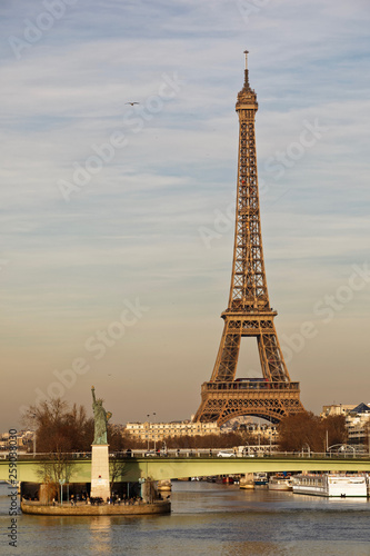 Paris, France - February 16, 2019: Liberty statue and Eiffel Tower near river seine in Paris