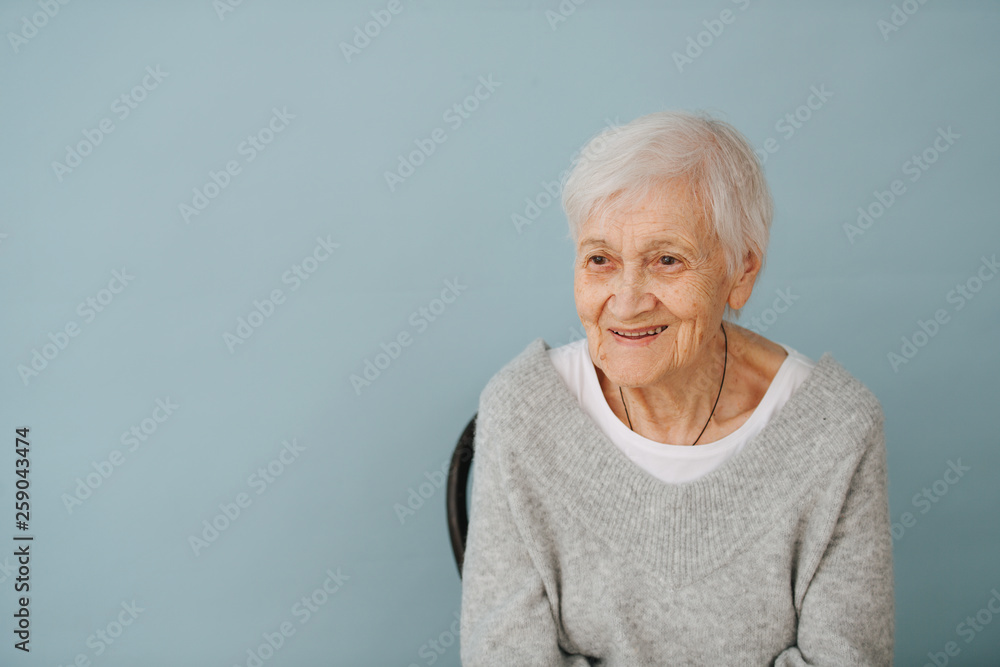 Portrait of elderely grey haired woman in a comfortable sweater at home Portrait of elderely grey haired woman in a comfortable sweater at home