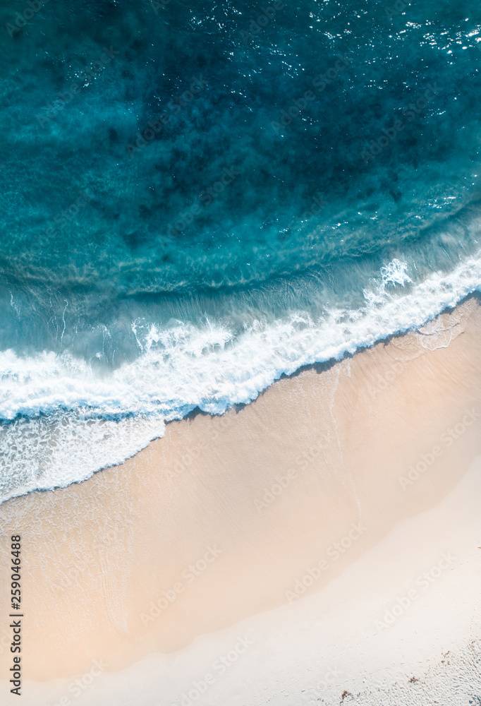 Aerial of a beach with waves at sunset with nice tones and warm summer vibes.