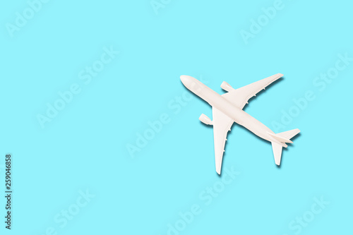 Model of white airplane on the light blue background