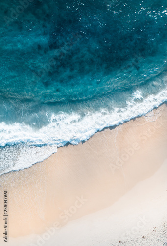 Ocean aerial landscape of surfer waiting for waves at sunrise with a beautiful light.