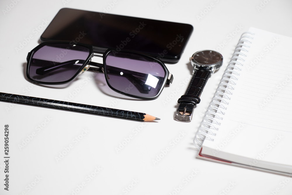 Flat lay smart phone notebook and pen sunglasses watch Flat lay smart phone notebook and pen sunglasses watch