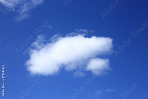 single fluffy white cloud on blue sky