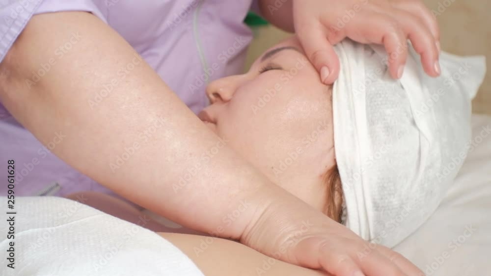 Asian girl in a beauty salon. Cosmetic procedure for skin rejuvenation and problem solving for the second chin. Facial and neck-collar massage. Close up. Health and beauty. Asian girl in a beauty salon. Cosmetic procedure for skin rejuvenation and problem solving for the second chin. Facial and neck-collar massage. Close up. Health and beauty.