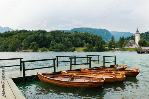 21 June 2018 Slovenia Four wooden boats on moored on a wooden pier Beautiful mountain view Selective focus
