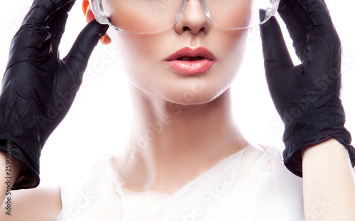 Close-up lipss, part of face of beautician woman, clean skin, protective glasses and gloves. Health care concept photo