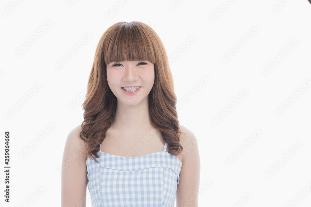 Front view close-up portrait of young beautiful Asian woman with curly long dark brown hair in light blue checked dress stand up straight isolated white background Front view close-up portrait of young beautiful Asian woman with curly long dark brown hair in light blue checked dress stand up straight isolated white background