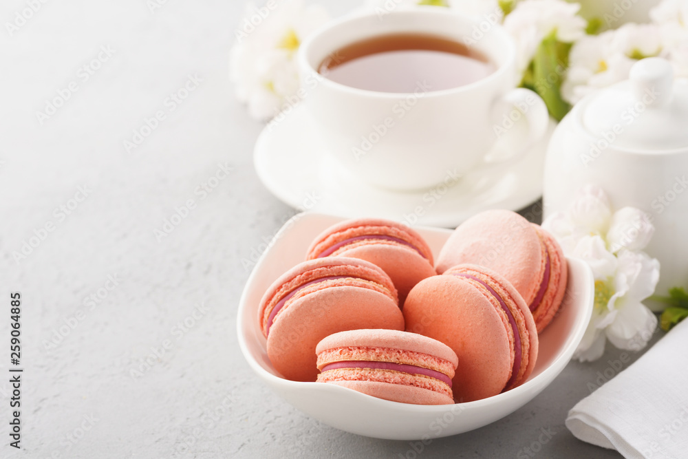 Pink french macarons with berry filling and tea for dessert. Pink french macarons with berry filling and tea for dessert.