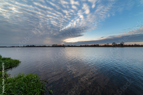 Fototapeta Naklejka Na Ścianę i Meble -  Beautiful evening sky with multicolored clouds over the quiet waters of Svityaz Lake.