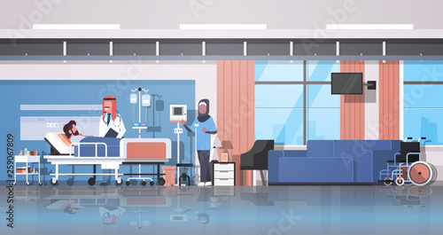 arab doctor and nurse in hijab visiting patient man lying bed with dropper intensive therapy ward healthcare concept hospital room interior medical clinic horizontal banner full length
