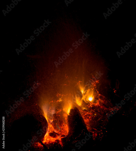 Burning fire in the night. Flame and fire sparkles on a dark abstract background. Hellish element of fire. Fuel, power and energy