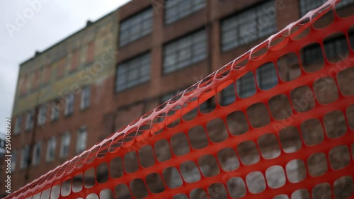 A condemned building behind some orange construction tape - V1