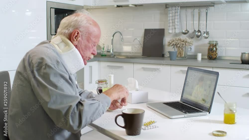 Sequence of videos with aged sick man in neck brace sitting at kitchen table at laptop screen and listening to female Caucasian doctor prescribing him pills via internet Sequence of videos with aged sick man in neck brace sitting at kitchen table at laptop screen and listening to female Caucasian doctor prescribing him pills via internet