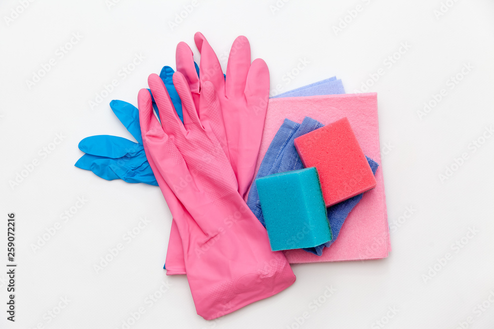 Bottles with detergent and cleaning tools on a light background. Colorful cleaning products. Home cleaning concept. Top view, close-up Bottles with detergent and cleaning tools on a light background. Colorful cleaning products. Home cleaning concept. Top view, close-up