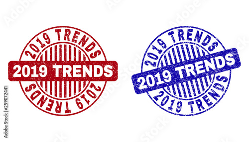 Grunge 2019 TRENDS round stamp seals isolated on a white background. Round seals with grunge texture in red and blue colors. Vector rubber watermark of 2019 TRENDS tag inside circle form with stripes.