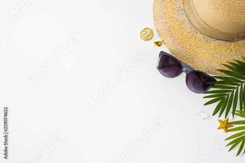 Flat lay summer beach holiday accesorries on white background with palm leaf, camera, straw hatand and sunglasses. Space for text. Travel and beach vacation, top view. Fashionable sunglasses. Minimal. photo