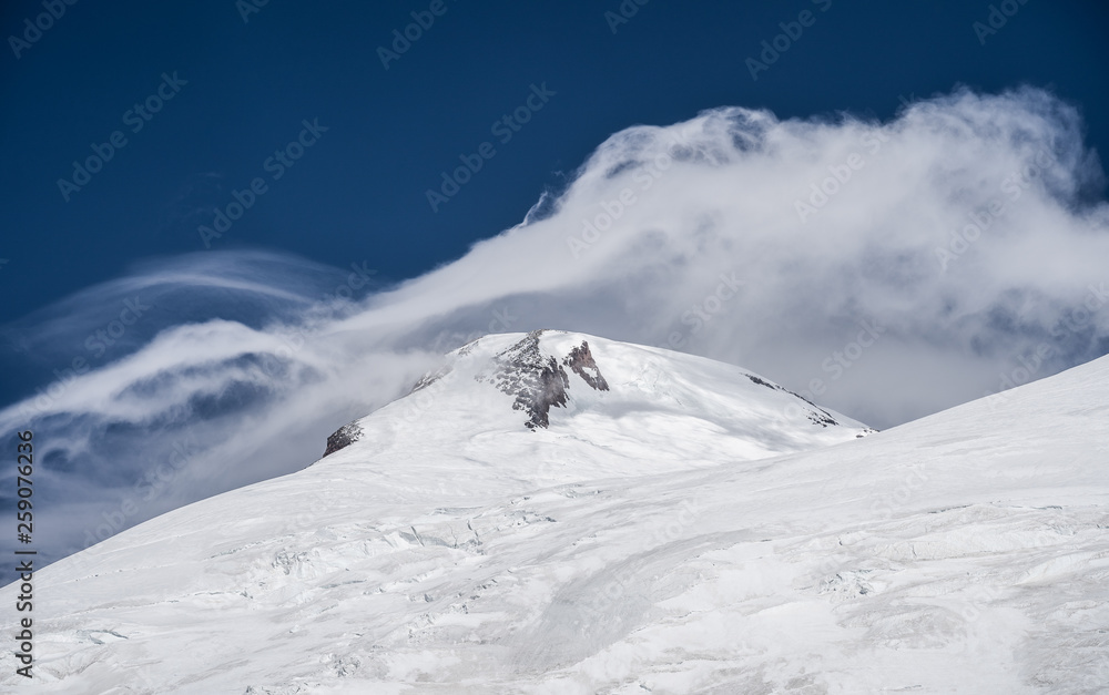 Amazing perspective of caucasian snow mountain or volcano Elbrus with blue sky background.
