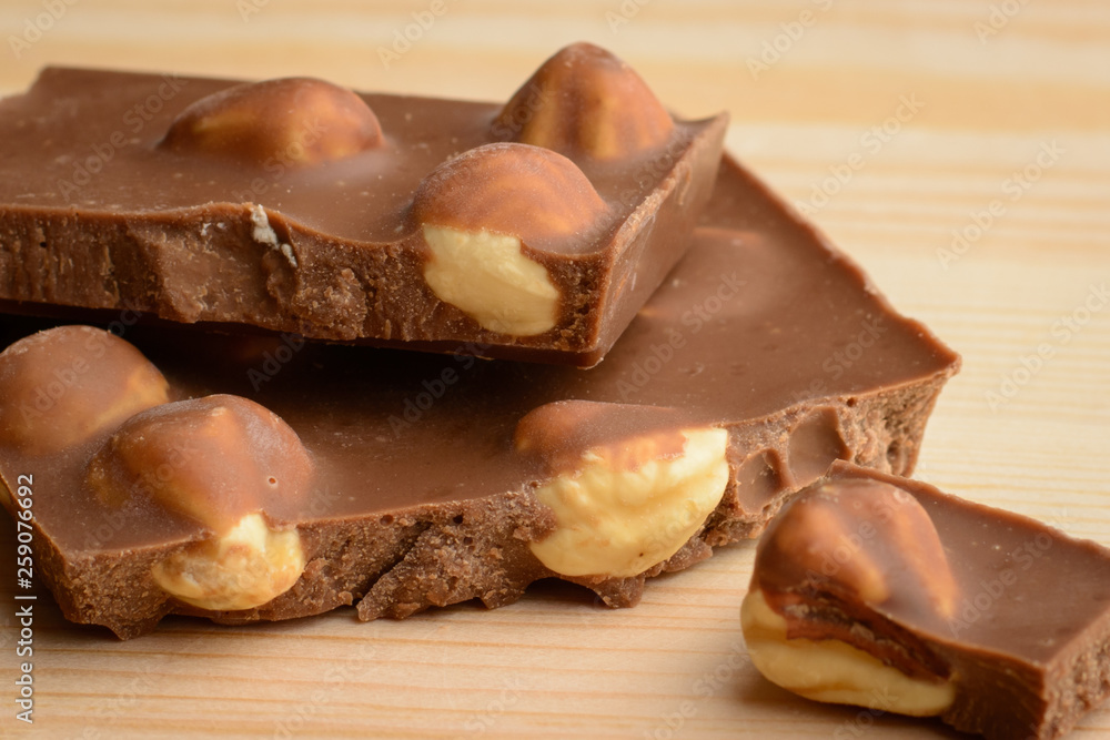 Close-up photo of delecious chocolate with nuts laying on wooden table Close-up photo of delecious chocolate with nuts laying on wooden table