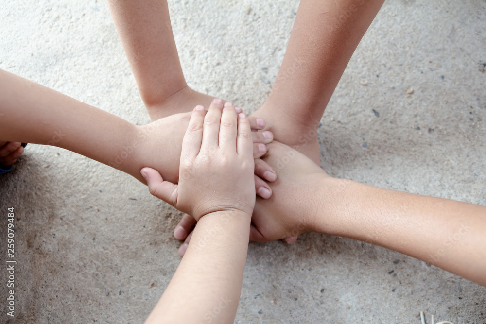 Group of children friends hands together joining concept Group of children friends hands together joining concept
