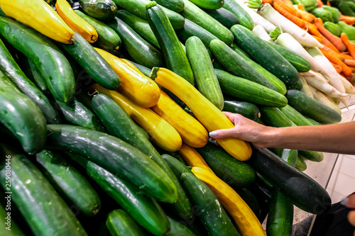 Vegetable background, fresh and shiny organic zucchinis or courgettes on a local food market, Bali island.