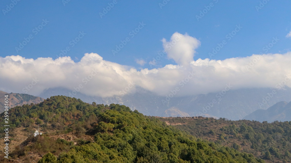 Naklejka premium Clouds over Mountains, Landscape in the mountains, View from the Indrunag, Dharmashala, Himachal Pradesh, India.