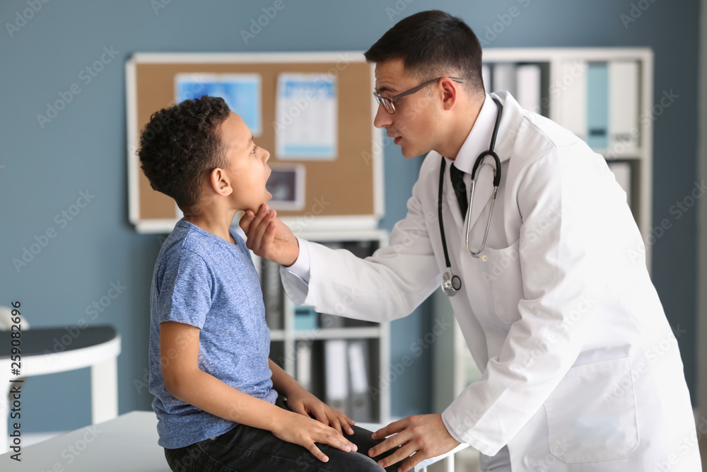 Pediatrician examining African-American boy in clinic Pediatrician examining African-American boy in clinic