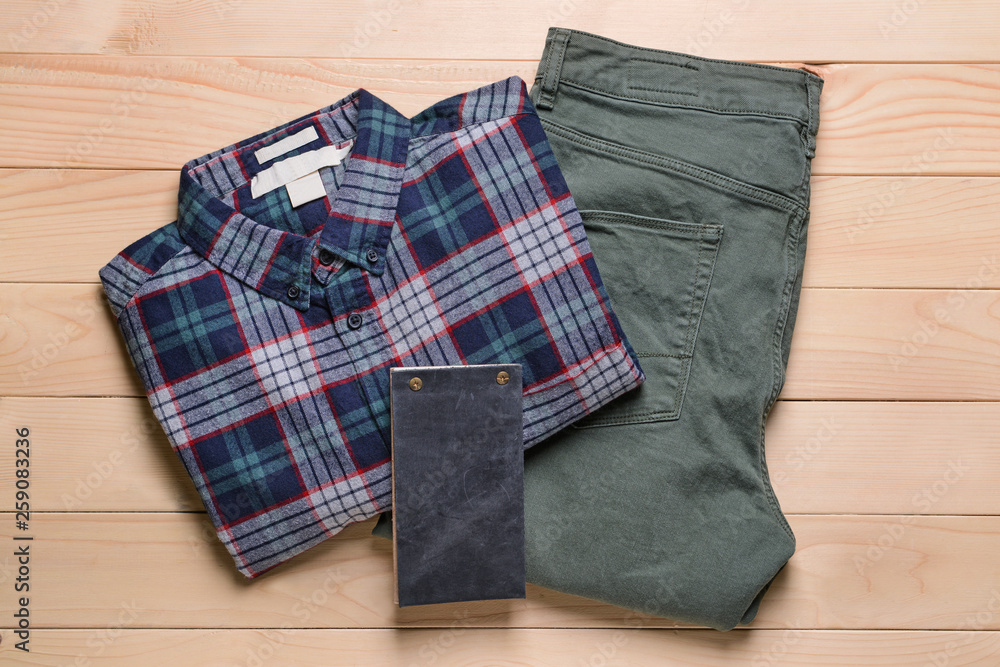 Male clothes with notebook on wooden background Male clothes with notebook on wooden background