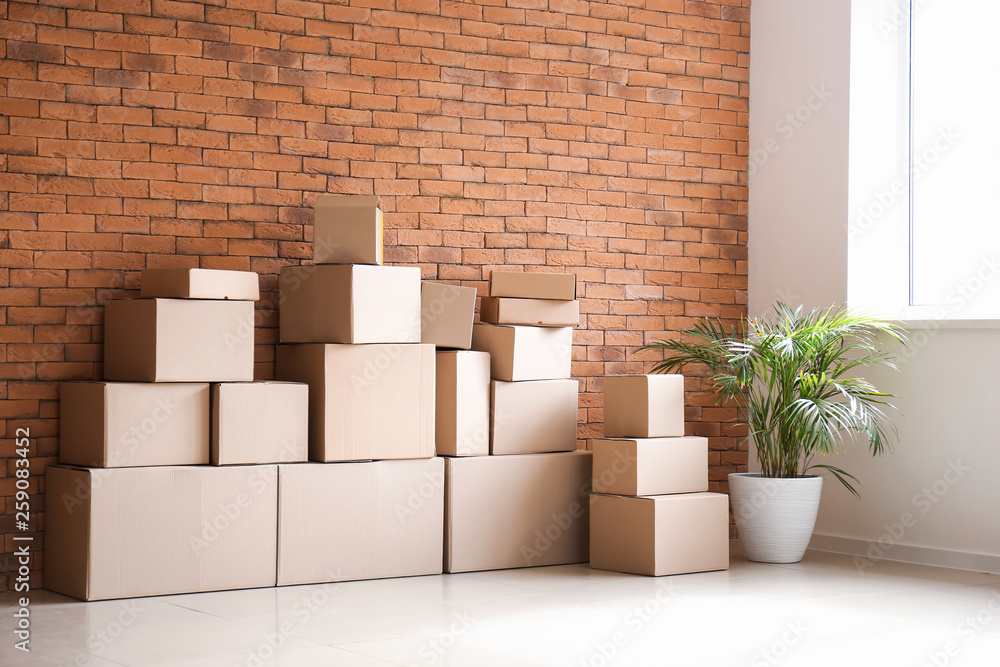 Moving boxes near brick wall in room Moving boxes near brick wall in room