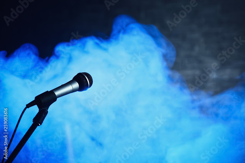 Modern microphone in smoke on stage