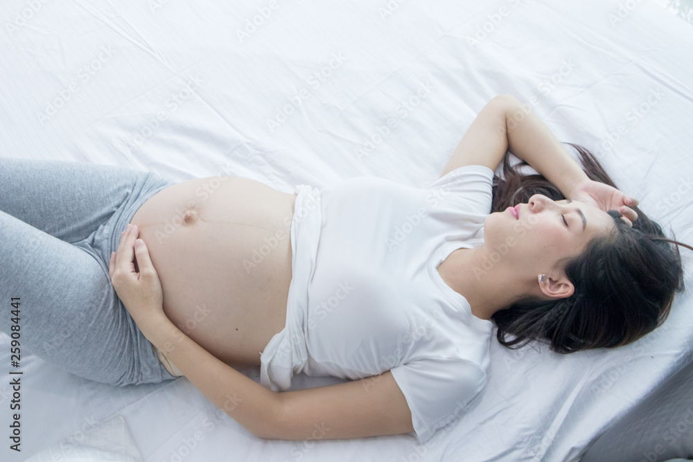 Portrait of Beautiful young pregnant woman in her bedroom.Pregnancy health care preparing for baby concept.Motherhood among teenage mother. Portrait of Beautiful young pregnant woman in her bedroom.Pregnancy health care preparing for baby concept.Motherhood among teenage mother.