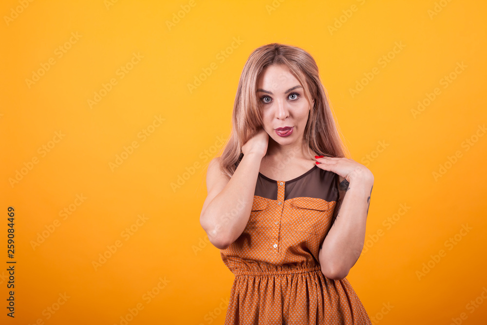 Attractive caucasian woman looking at the camera over yellow background Attractive caucasian woman looking at the camera over yellow background